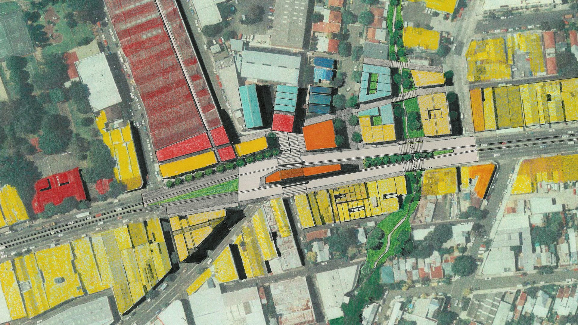 A detailed aerial view of an urban area highlighting a transportation corridor along Parramatta Road. Buildings are color-coded in red, orange, yellow, and green. Streets and intersections are clearly visible, with a central segment featuring pathways and green spaces.