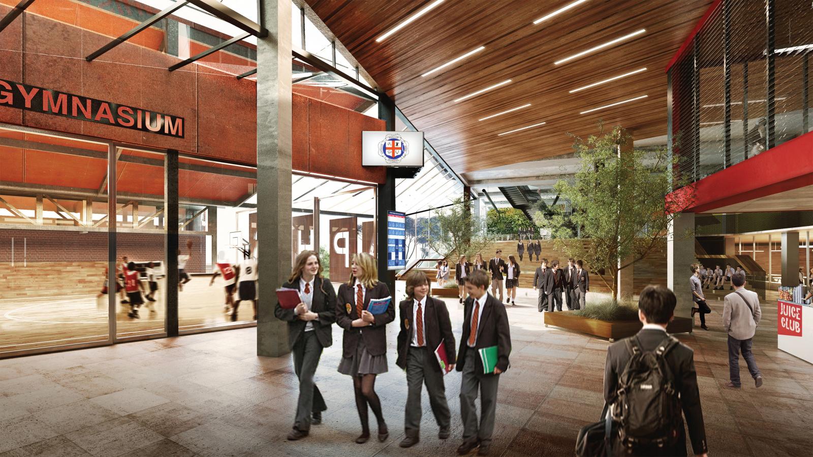 Interior of a modern school building in Parramatta with a visible gymnasium on the left. At Arthur Phillip School, students in uniforms holding books and bags walk through an open, well-lit foyer with wooden ceiling panels and greenery. Some students play basketball in the open gym.