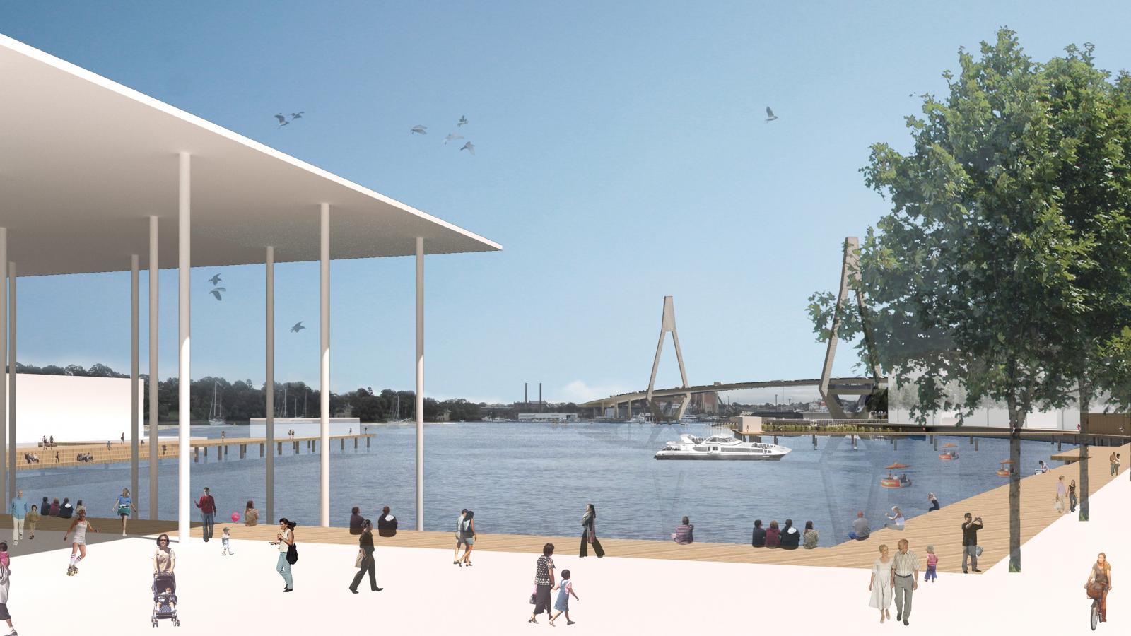 A lively riverside scene with people walking along the waterfront promenade and engaging in various activities. A modern pedestrian bridge spans the river, and boats are visible on the water. Trees and outlines of buildings are in the background under a bright blue sky.