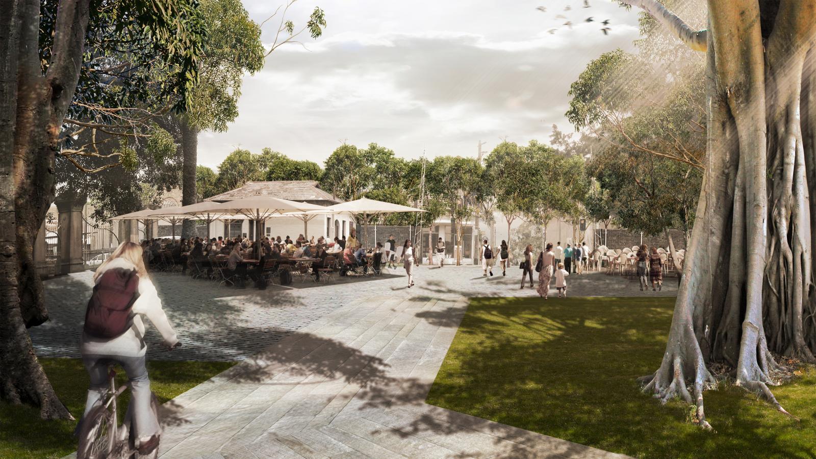 A bustling outdoor cafe scene with people sitting under umbrellas and among trees, reminiscent of the vibrant spaces envisioned in the Master Plan for Callan Park. In the foreground, a person rides a bicycle past the cafe, while others walk or sit at tables. The lively atmosphere mixes natural greenery with paved paths.