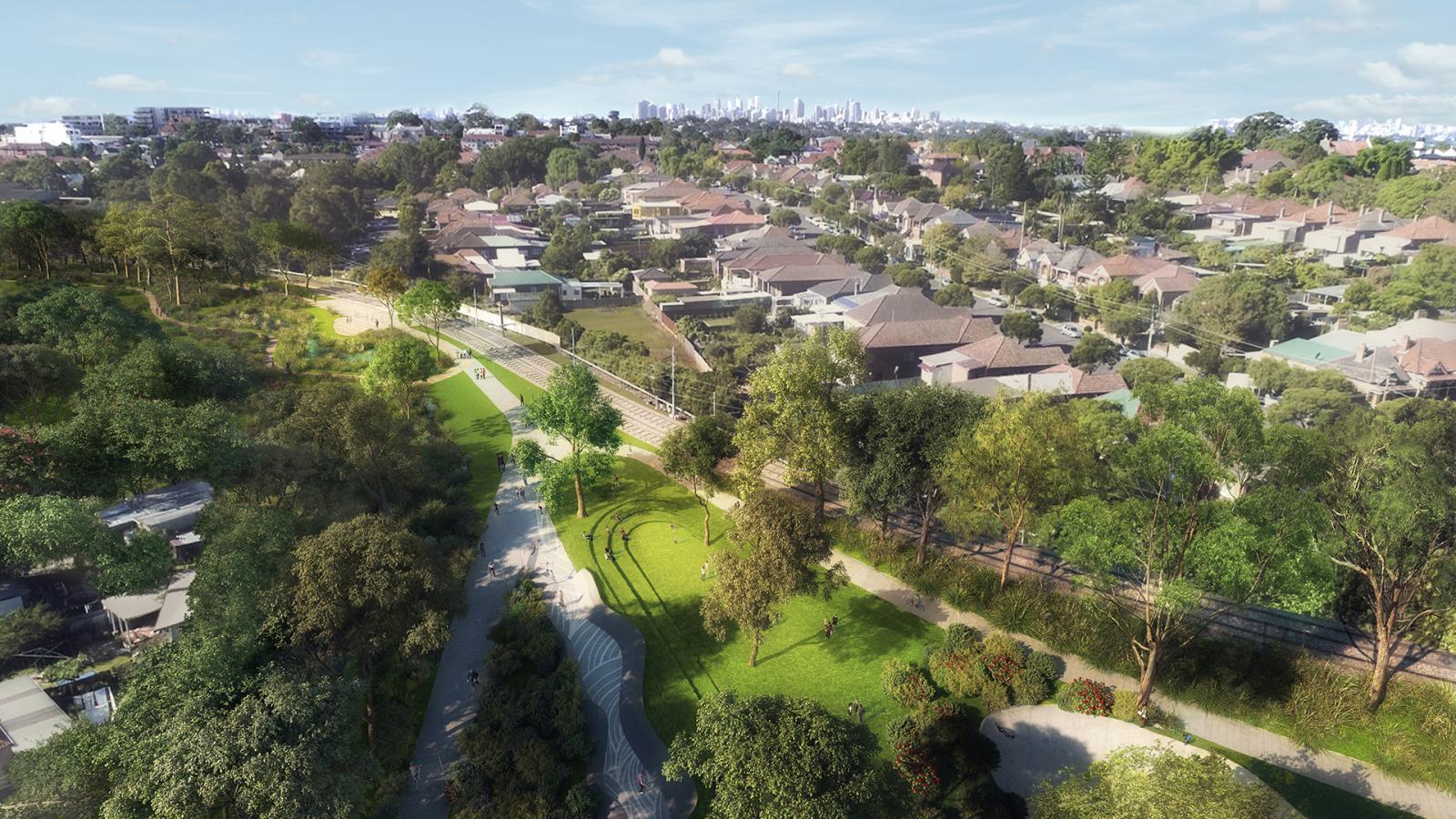 Aerial view of a suburban neighborhood surrounded by lush greenery. A well-maintained park, named GreenWay, with walking paths, trees, and open grassy areas lies in the foreground. Rows of houses are visible in the middle, with a distant city skyline in the background.