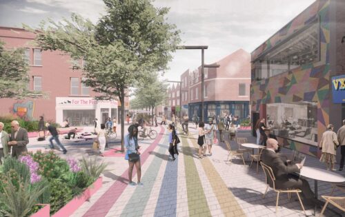 A lively outdoor urban space on East Street features colorful pathways. People walk, sit at outdoor tables, and engage in various activities. Buildings line the street, including a café with a "Vegan" sign. Trees and plants add greenery to this scene of vibrant renewal.