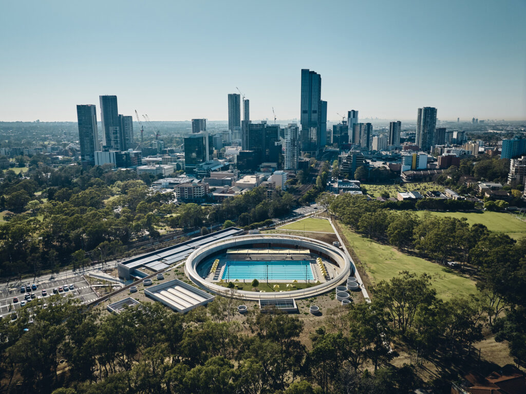 Aerial view of Parramatta Aquatic Centre with a background of the Parramatta skyline.