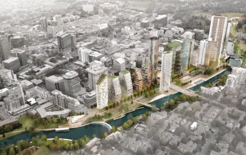 A bird's-eye view of Parramatta reveals a modern urban development with several high-rise buildings lining the waterway. The cityscape features a mix of contemporary architecture with green rooftop terraces, surrounded by a blend of residential and commercial buildings as part of the River Plan.