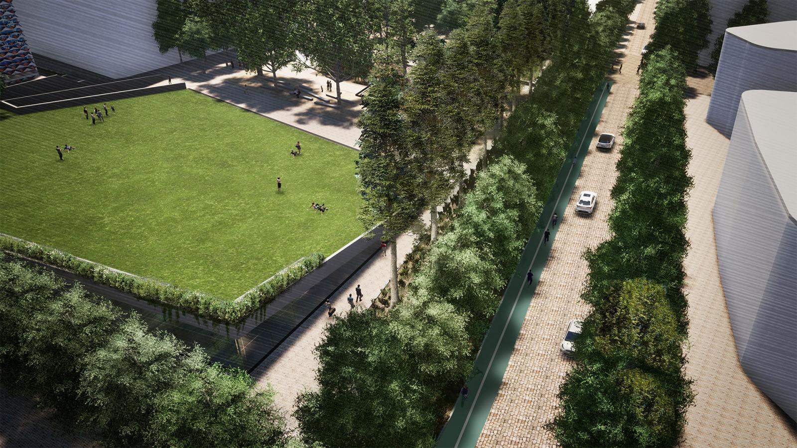 Aerial view of Paul Keating Park featuring a large, rectangular grassy area with a few people on it. Adjacent to the park is a cobblestone road lined with trees and several parked cars. Buildings surround the park area, and walking paths can be seen.