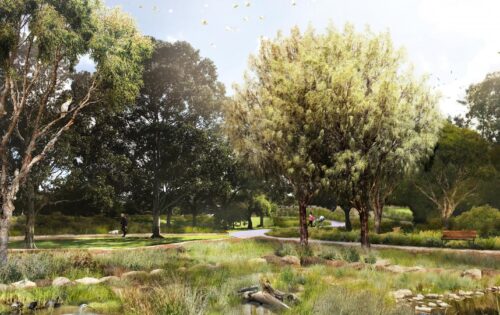 A scenic park landscape in Sydney features a walking path, trees, and a small pond. Birds can be seen flying in the clear sky and perched near the water. People are strolling along the path, with a bench placed by the trail's side. Bushes and tall grasses border the pond beautifully.