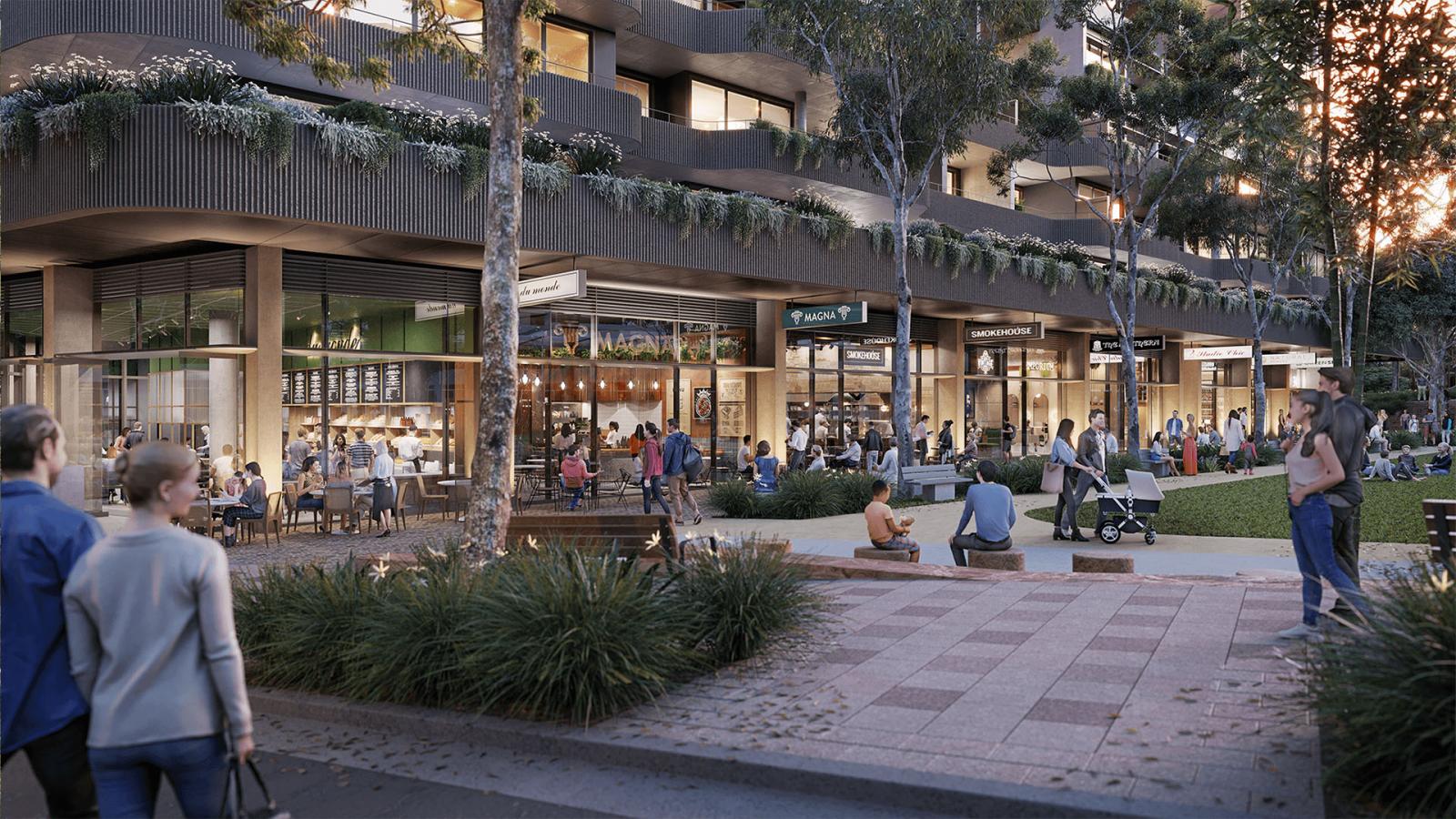 Image of a lively urban plaza bordered by shops and restaurants, with people walking, chatting, dining, and sitting on benches. Modern multi-story buildings from the Ivanhoe Estate with balconies and greenery line the background, while trees and landscaped plants add to the vibrant atmosphere.