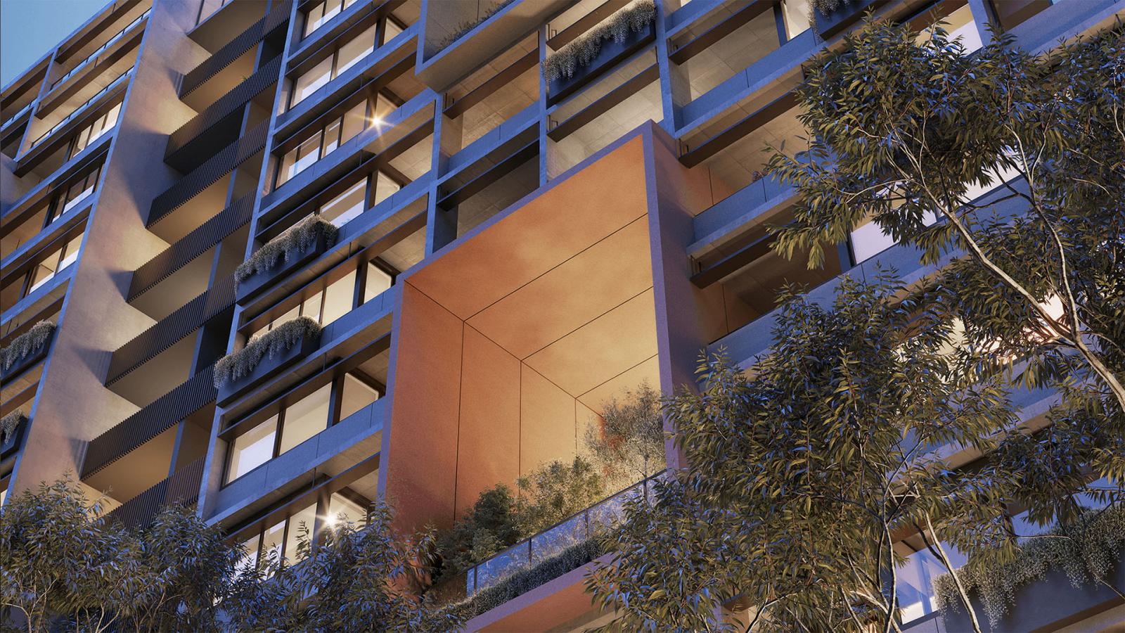 A modern, multi-story building exterior with large windows and balconies stands tall in the Ivanhoe Estate. Some balconies have plants, adding greenery to the facade. A distinct, recessed orange balcony stands out among the grey structure, while trees are visible in the foreground, evoking a sophisticated treehouse vibe.