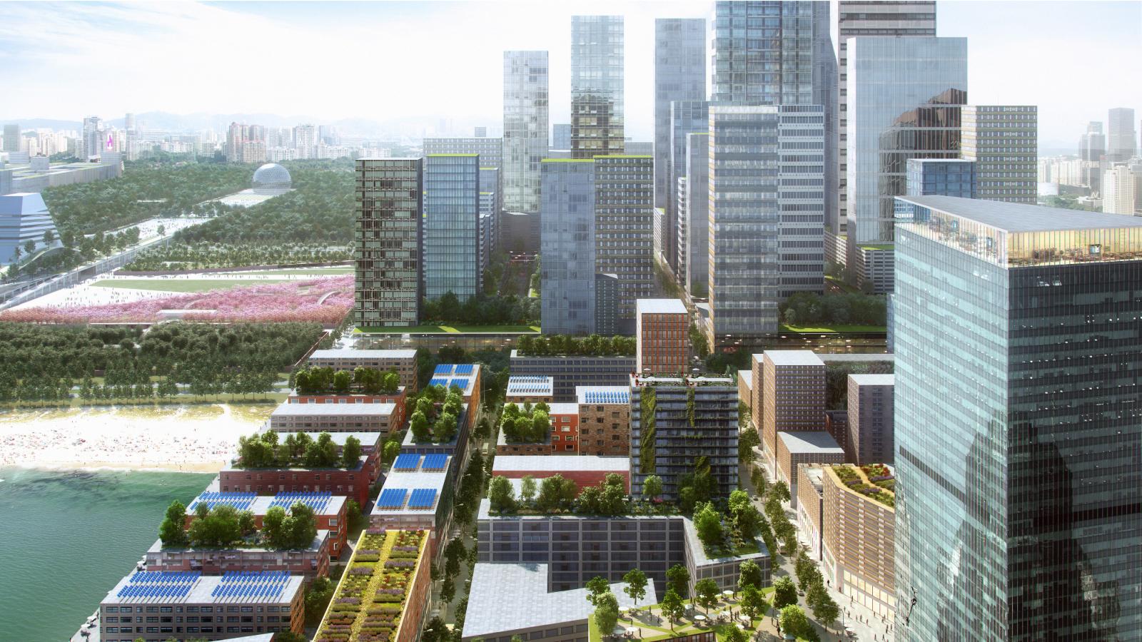 A modern cityscape featuring a mix of tall glass skyscrapers and mid-rise buildings with greenery on the rooftops. The foreground shows tree-lined streets and buildings with solar panels. In the background, a river and the sprawling Xiangmihu Park are visible.