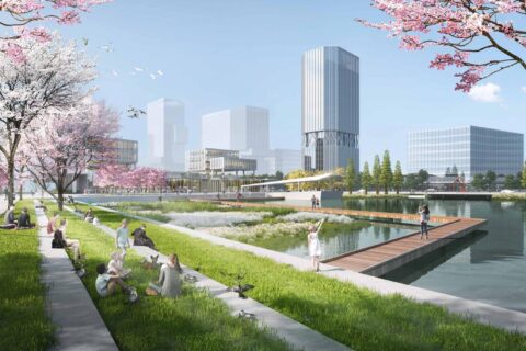 A modern park near the Luhua River, surrounded by blooming cherry blossom trees, epitomizes expert landscape planning. People are sitting on the grass, walking, and enjoying the environment. Skyscrapers form the backdrop under a clear blue sky as a wooden walkway extends over the water.