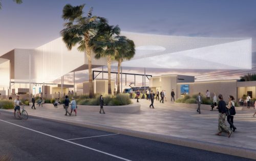 A modern open-air transit station at dusk, designed for the Frankston competition, boasts a unique white canopy, tall palm trees, and a spacious plaza. People are seen walking, biking, and socializing. The area is well-lit with a blend of natural and artificial light, creating a welcoming atmosphere.