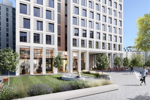 A modern apartment building with large windows and a courtyard featuring landscaping, benches, and a central sculpture stands near Bristol's tallest building. Pedestrians walk along the broad sidewalk, while people are seated at an outdoor café to the right. Trees and other buildings are in the background.