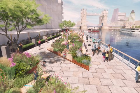 A bustling riverside promenade at Butler's Wharf features people walking, sitting on benches, and dining outdoors under trees and umbrellas. The scene is adorned with lush flower beds. Tower Bridge stands in the background over the river, where boats and birds are visible.