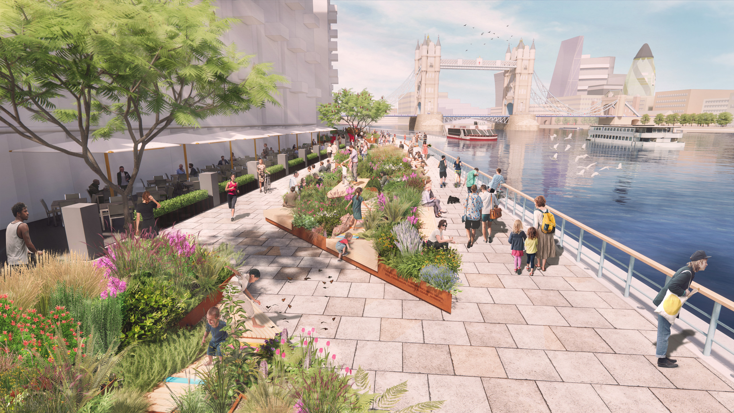 A bustling riverside promenade at Butler's Wharf features people walking, sitting on benches, and dining outdoors under trees and umbrellas. The scene is adorned with lush flower beds. Tower Bridge stands in the background over the river, where boats and birds are visible.