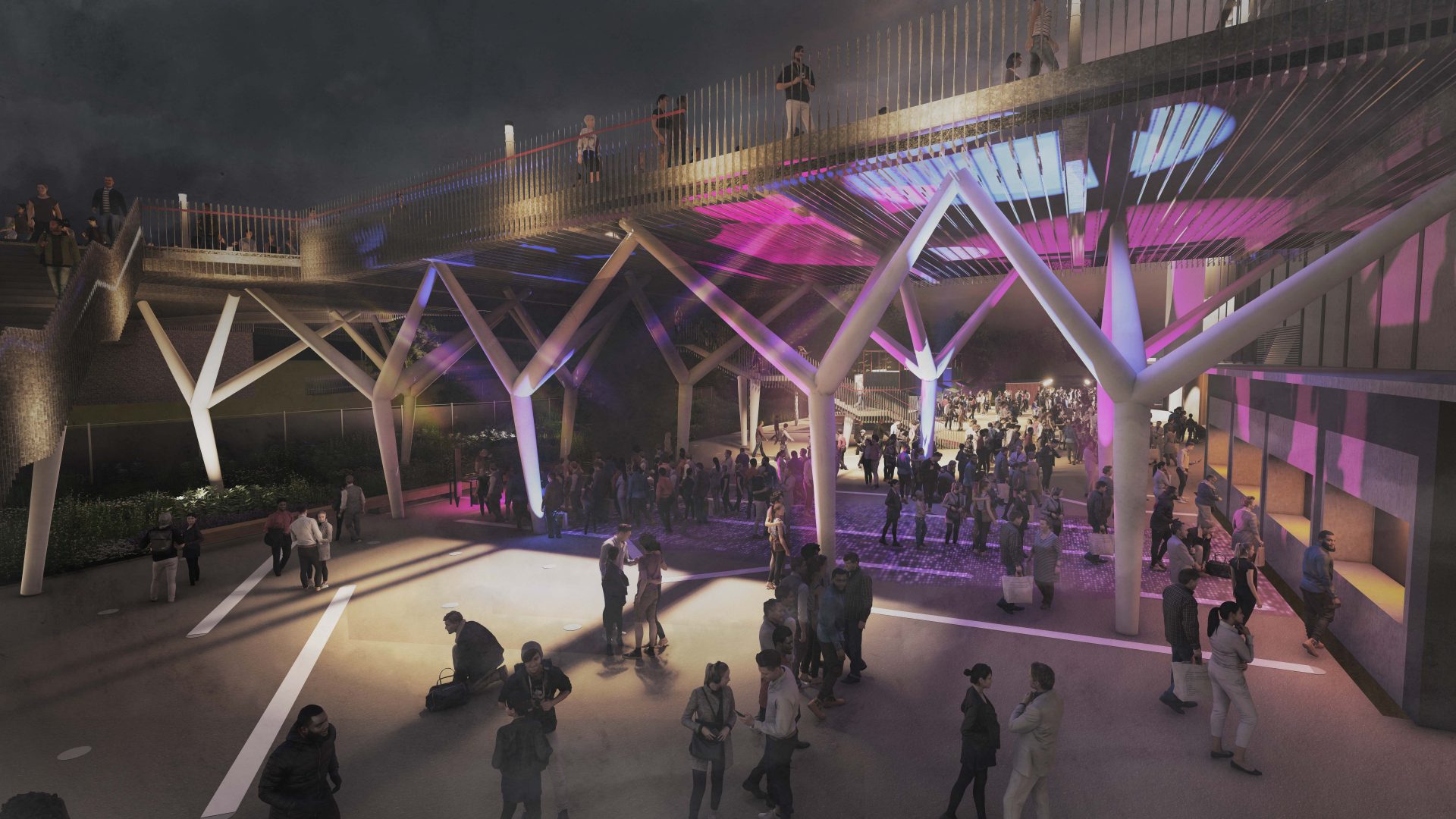 A night-time scene at the YTL Arena features a lively crowd gathered under a modern structure with colorful lights. The structure has crisscrossing beams and a pedestrian walkway overhead. Shadows and vibrant hues add energy to the social atmosphere.