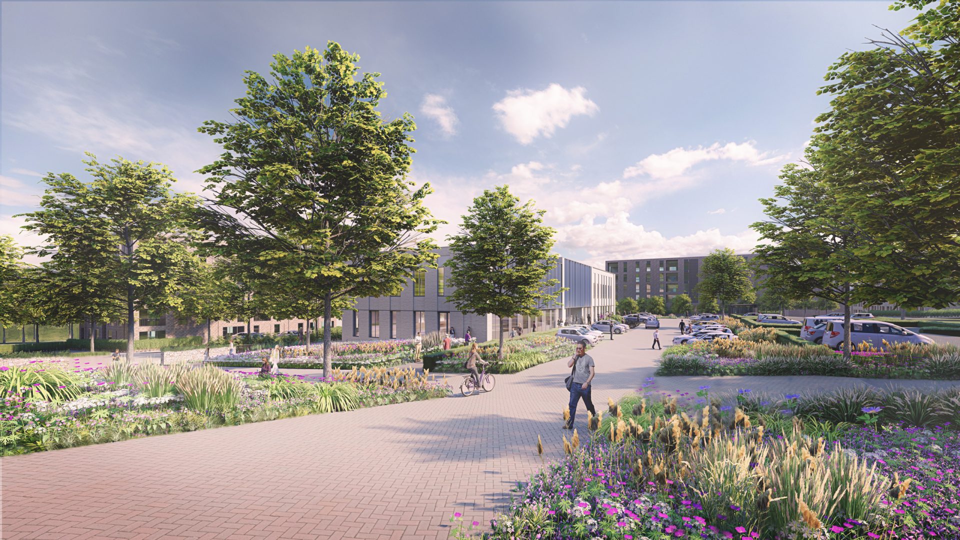 A scenic outdoor pathway lined with trees and vibrant flowerbeds graces the park in Oxford. Several people walk, cycle, or relax on benches along the path. Modern buildings, a testament to innovation, are visible in the background, and a parking area with a few cars is on the right side. The sky is partly cloudy.