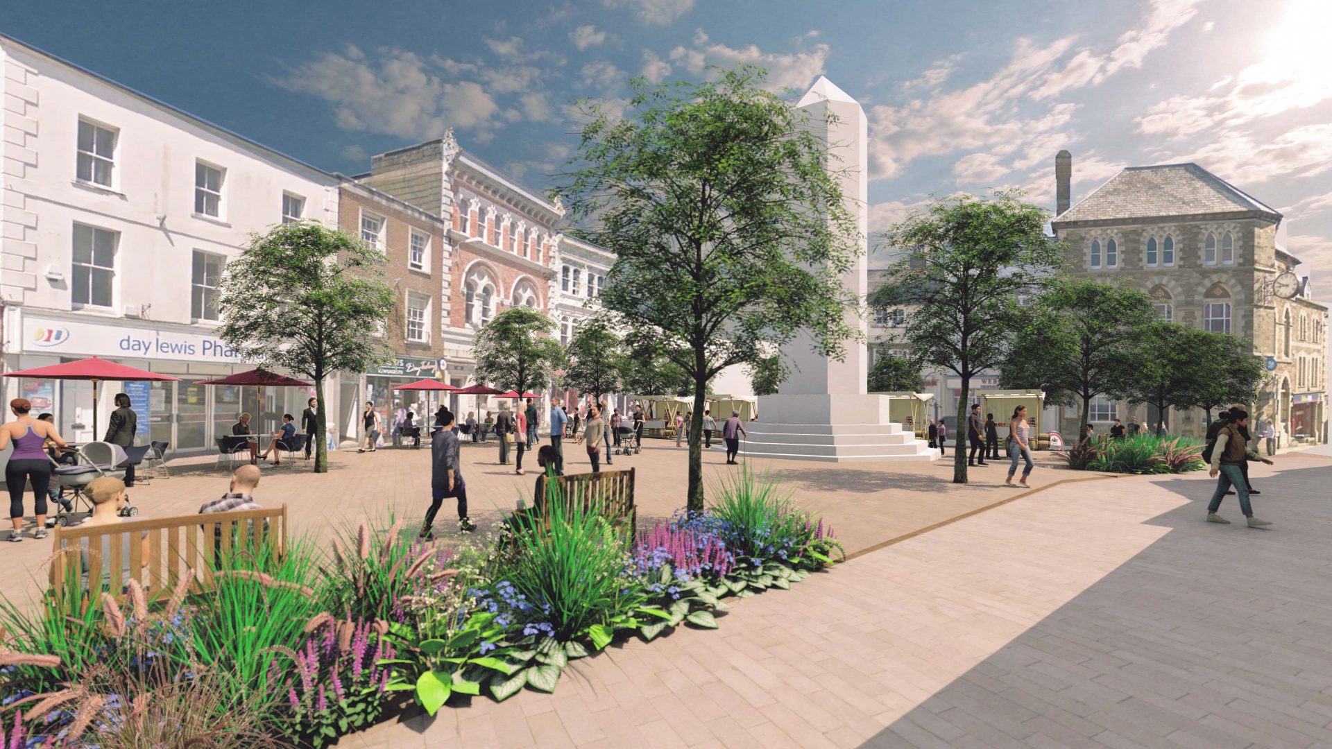 A lively town square in Launceston with people walking and sitting on benches. The square features greener streets with trees, flower beds, and a tall obelisk monument in the center. Surrounding the square are historic buildings with shops and cafes. The sky is clear and sunny.