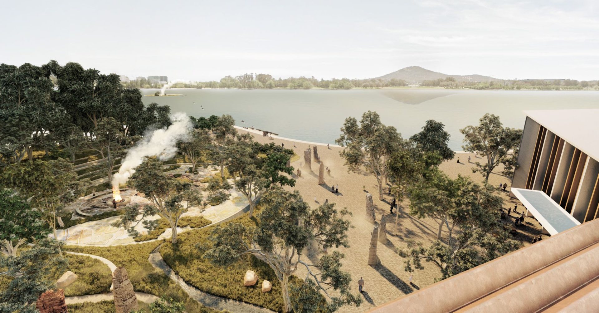 A scenic lakeside view shows a winding path lined with trees and benches, leading to a body of water. A smoking campfire is visible in a small clearing to the left, while a modern building with a slanted roof, part of the new Cultural Precinct proposal known as Ngurra, is seen on the right. Distant hills frame the horizon.