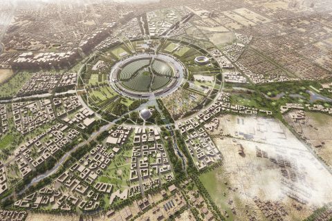 Aerial view of a massive futuristic city with a large, circular central hub known as the Circular District, surrounded by several rings of green spaces, buildings, and water features. Radiating outward from the hub are numerous roads and pathways connecting to urban areas and sprawling fields.