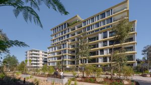 The modern residential building, NINE by Mirvac, boasts multiple stories with large windows and balconies. Nestled near Henderson Park, the landscaped area features trees and walkways. Under a clear blue sky, two people sit on a bench in the foreground, enjoying the peaceful surroundings.